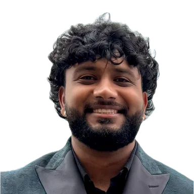 Mridul Sharma, smiling, in a dark green suit
